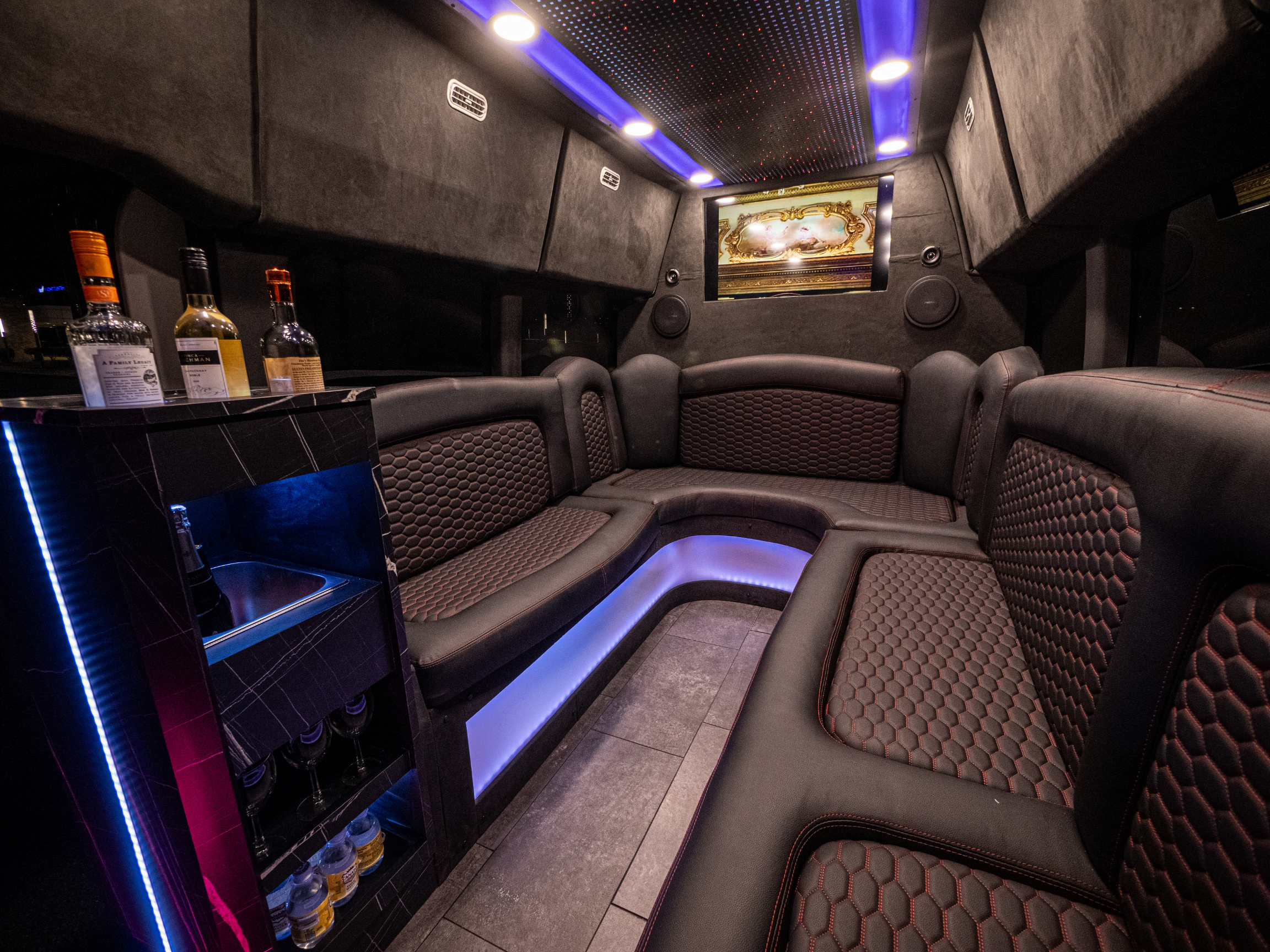 Luxury Van Limo party bus interior in Puerto Rico with minibar, leather seating, and LED lights